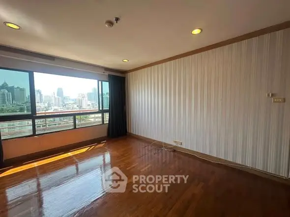 Spacious room with city view and wooden flooring in high-rise building
