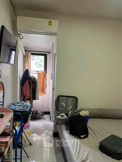 Cozy bedroom with air conditioning and natural light, featuring a small closet and modern decor.