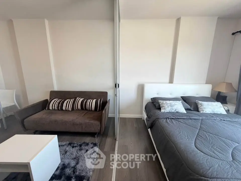 Modern studio apartment with cozy living area and comfortable bed, perfect for urban living.