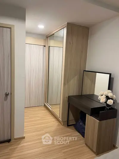 Modern bedroom with sleek wooden flooring and stylish wardrobe, perfect for contemporary living.