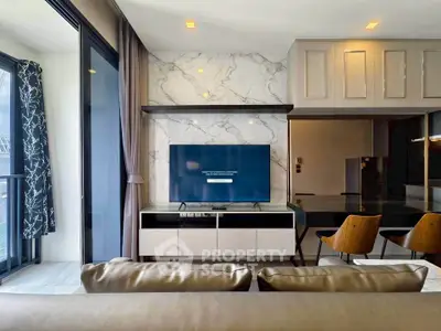 Modern living room with sleek design, featuring a large TV, stylish furniture, and marble accents.