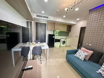 Modern living room with open kitchen, featuring stylish decor and integrated appliances.