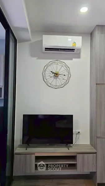 Modern living room with sleek TV stand and wall-mounted air conditioner, perfect for cozy entertainment.
