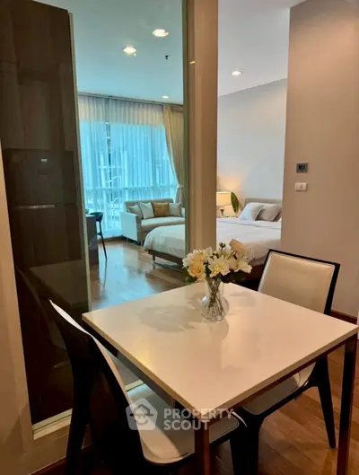 Modern apartment interior with cozy dining area and elegant bedroom view.