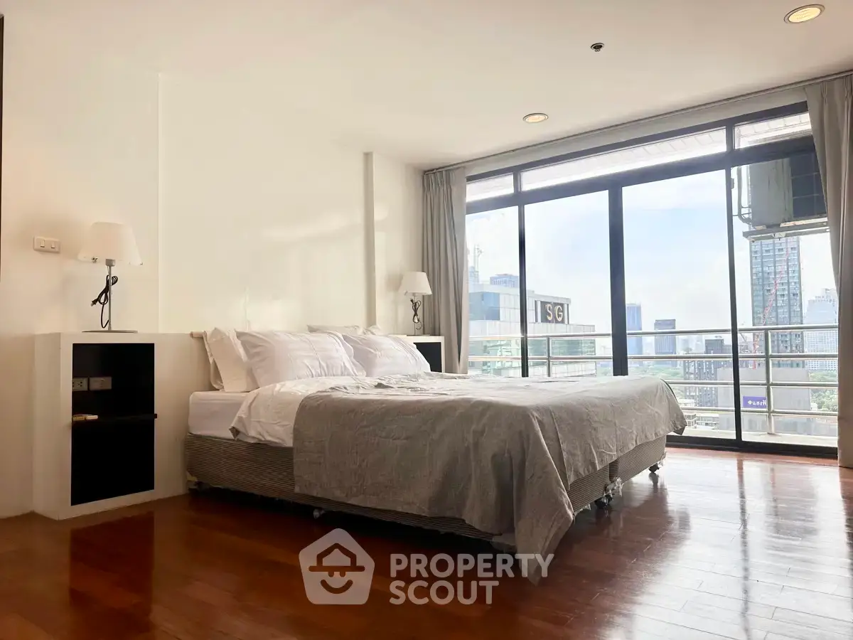 Spacious bedroom with city view and large windows in modern apartment