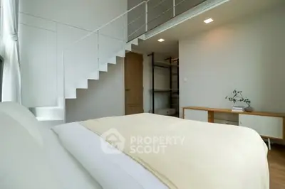 Modern bedroom with minimalist design and loft-style staircase