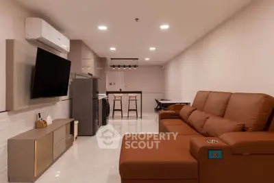 Spacious modern living room with sleek furniture and open kitchen layout