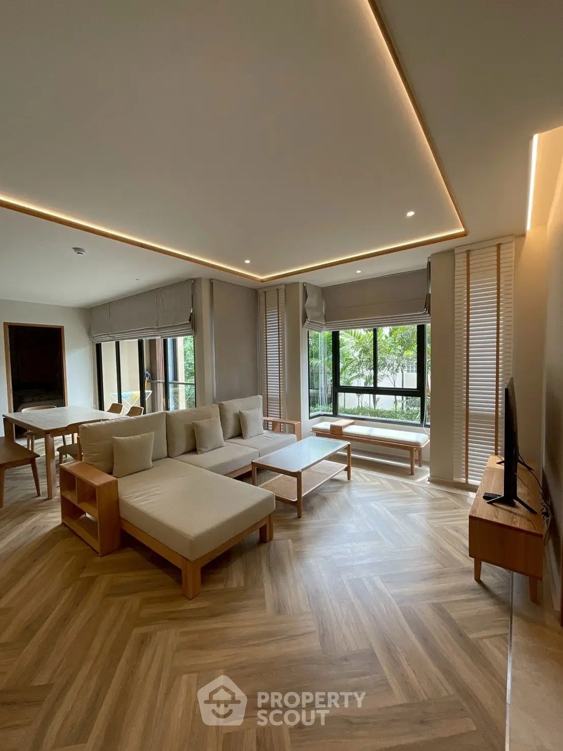 Spacious modern living room with elegant wooden flooring and large windows.