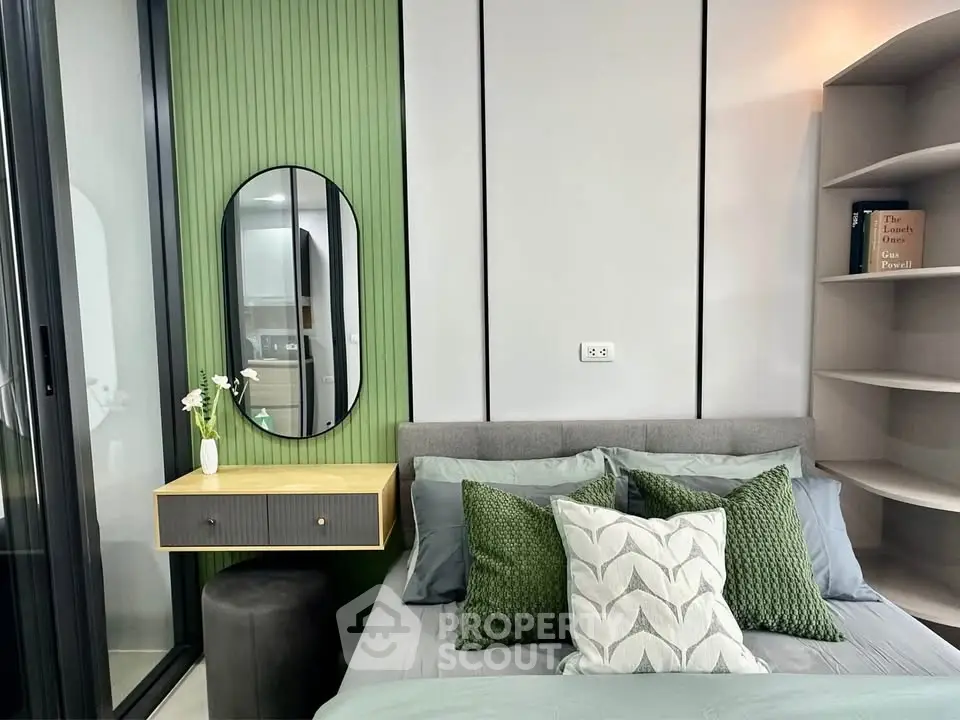 Modern bedroom with stylish decor and green accents, featuring a cozy bed and elegant mirror.