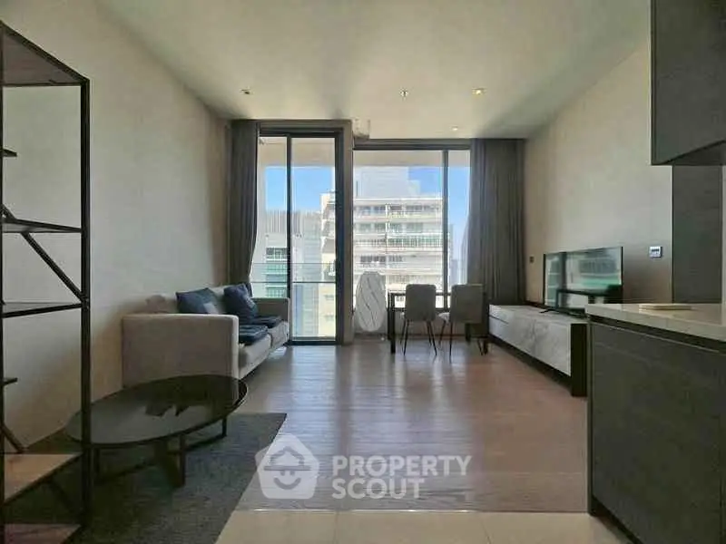 Modern living room with large windows and stylish furniture in a high-rise apartment.