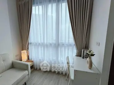 Cozy study nook with natural light and elegant curtains in modern apartment.