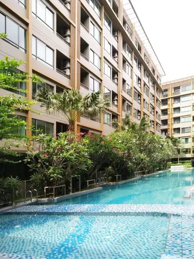 Luxurious apartment complex with stunning pool and lush greenery, perfect for modern living.