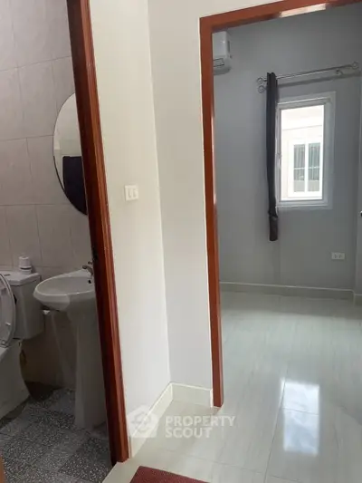Spacious bathroom with adjacent room, modern fixtures, and natural light.