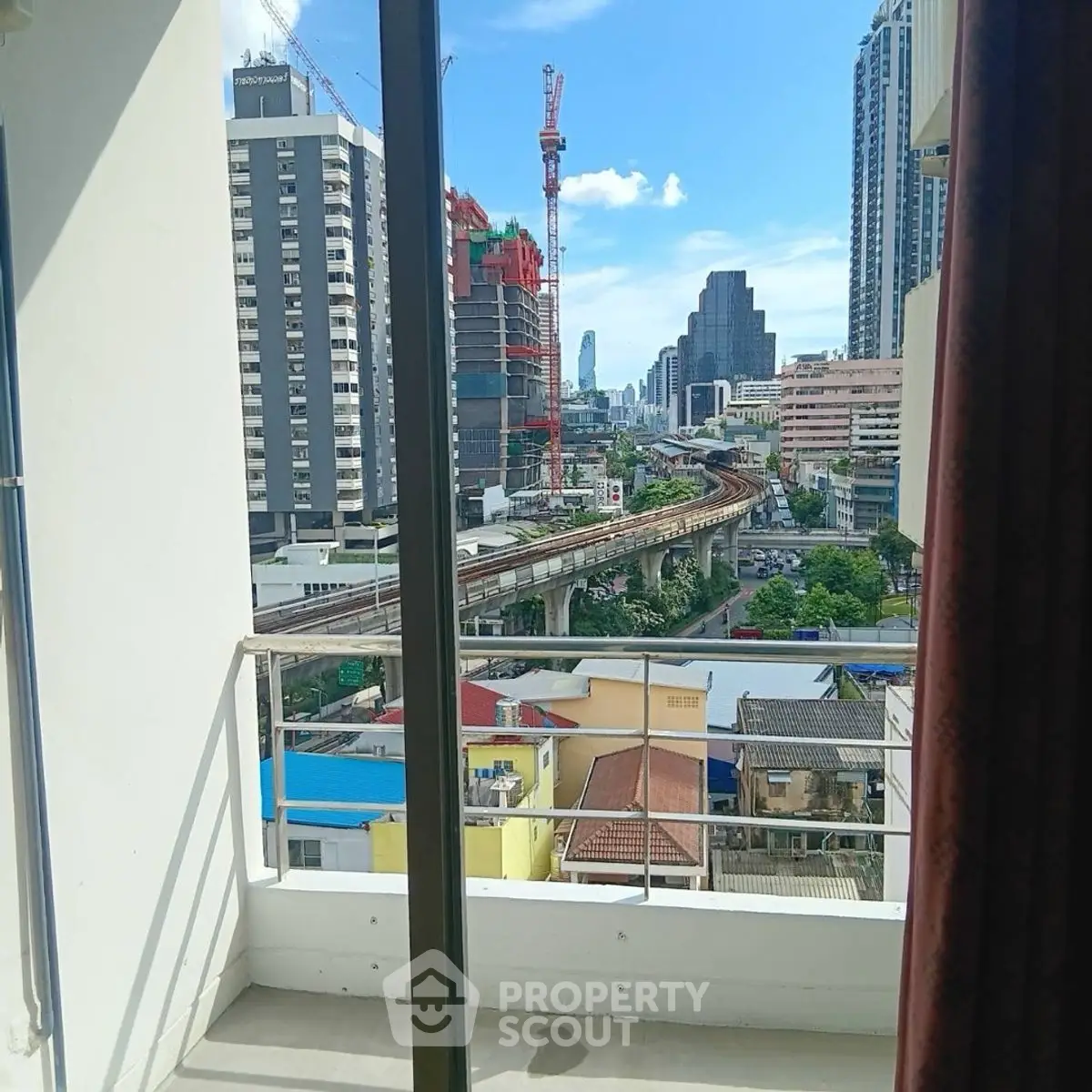 City view from a balcony with urban skyline and railway track