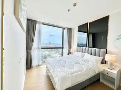 Bright and modern bedroom with large windows offering stunning city views, perfect for relaxation.
