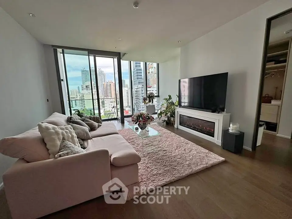 Luxurious living room with city view, plush sofa, and modern decor in high-rise apartment.