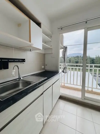 Bright kitchen with open layout and balcony view