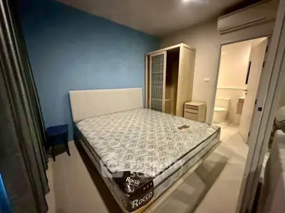 Cozy bedroom with modern furnishings and ensuite bathroom in stylish apartment.