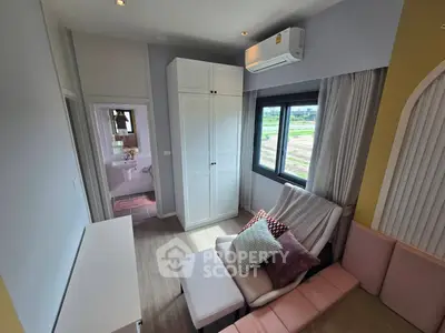 Cozy living room with modern decor and large window offering scenic views
