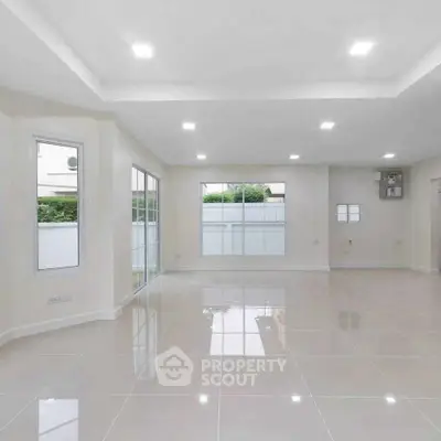 Spacious modern living room with large windows and glossy tiled floors