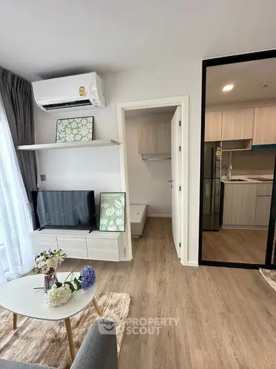 Modern living room with sleek design, featuring a TV, air conditioning, and stylish decor in a cozy apartment.