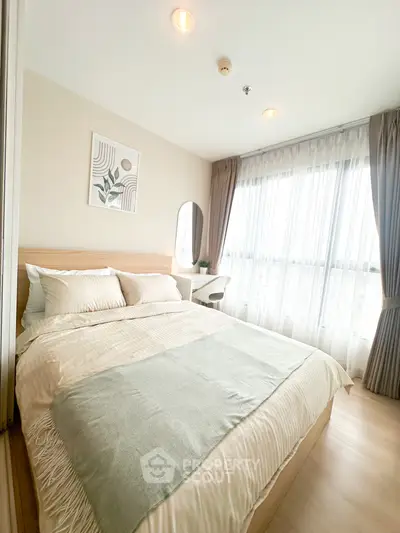 Cozy and bright bedroom with modern decor and large window for natural light.
