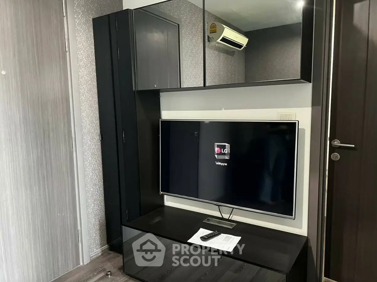 Modern living room with sleek TV unit and air conditioning in stylish apartment.