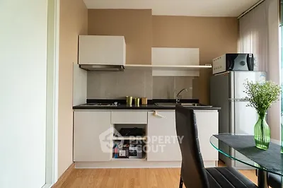 Modern kitchen with sleek cabinets and dining area in stylish apartment