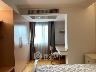 Cozy bedroom with built-in wardrobe and study desk, featuring natural light and modern design.
