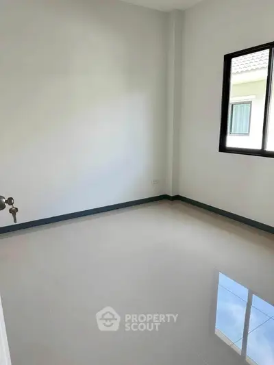Spacious empty room with large window and glossy tiled floor, perfect for customization.