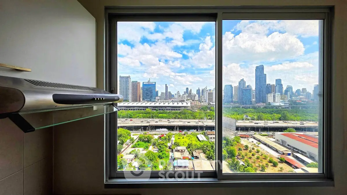 Stunning cityscape view from modern apartment window with lush greenery and skyline.