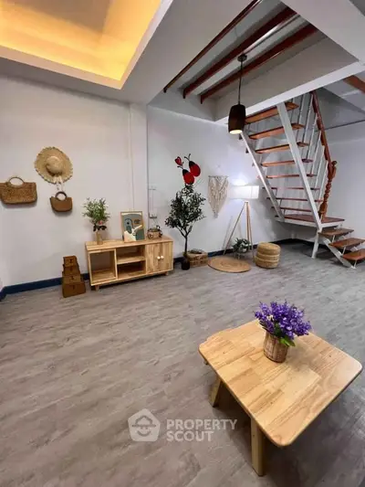 Charming living room with modern decor and stylish staircase, perfect for cozy gatherings.