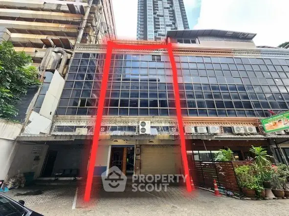 Commercial building exterior with large glass windows and urban surroundings, ideal for business opportunities.