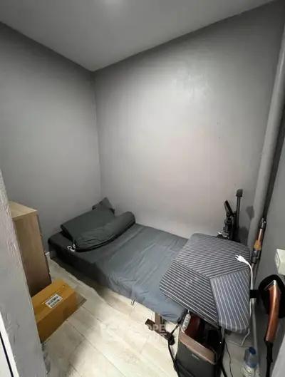 Compact bedroom with minimalist decor and modern gray walls, ideal for urban living.
