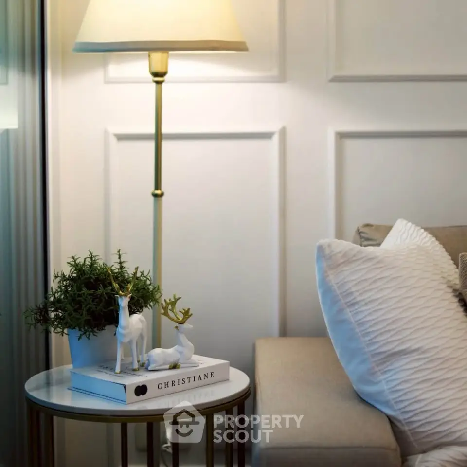 Elegant living room corner with cozy sofa, stylish lamp, and decorative accents for a serene ambiance.