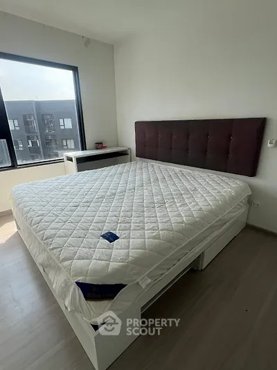 Spacious bedroom with large window and modern bed in a bright apartment
