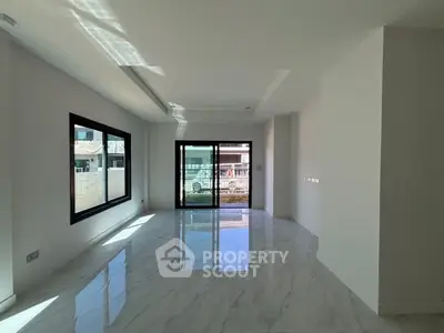 Spacious modern living room with large windows and marble flooring
