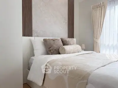 Elegant bedroom with plush bedding and natural light, perfect for relaxation.