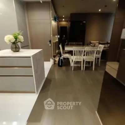 Modern open-plan living and dining area with elegant decor and wooden flooring.