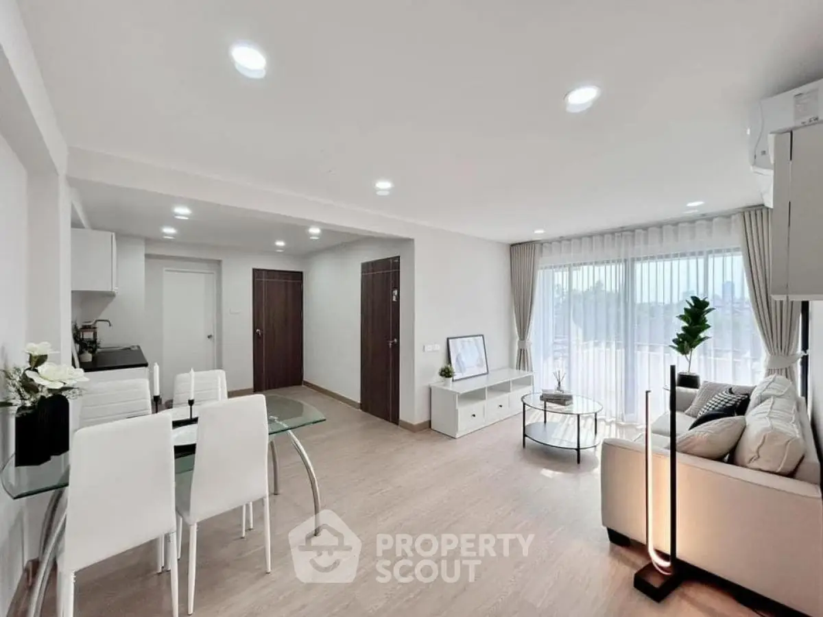 Modern open-plan living room with dining area and large windows