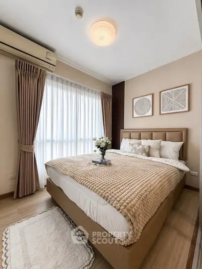Cozy bedroom with elegant decor and natural light, featuring a plush bed and stylish wall art.