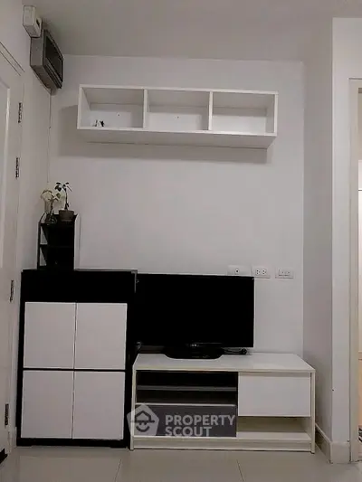 Modern living room with sleek TV stand and wall-mounted shelves in minimalist design.