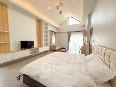 Spacious modern bedroom with high ceiling and natural light