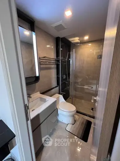 Modern bathroom with glass shower and sleek fixtures in luxury apartment