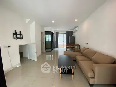 Spacious modern living room with sleek tile flooring and cozy sectional sofa, perfect for relaxation.