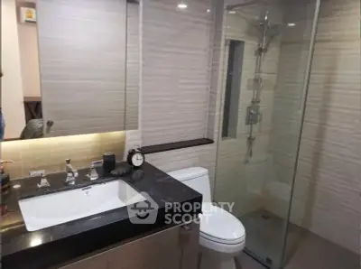 Modern bathroom with sleek design and glass shower enclosure.