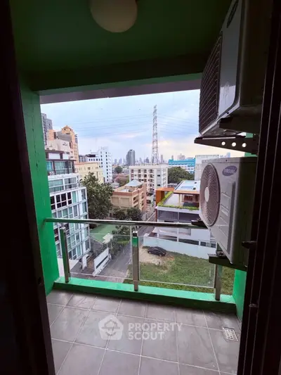 Charming balcony with cityscape view and air conditioning units, ideal for urban living.