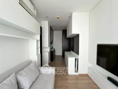 Modern living room with sleek white cabinetry and cozy gray sofa