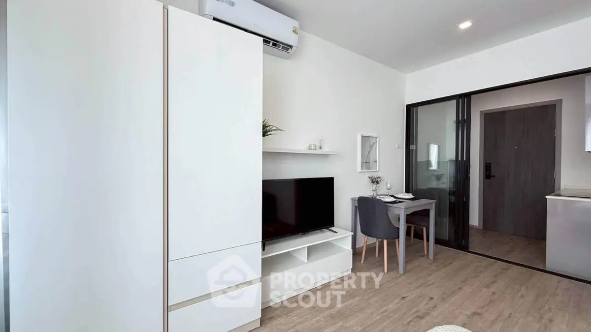 Modern living room with sleek furniture and dining area in a stylish apartment.