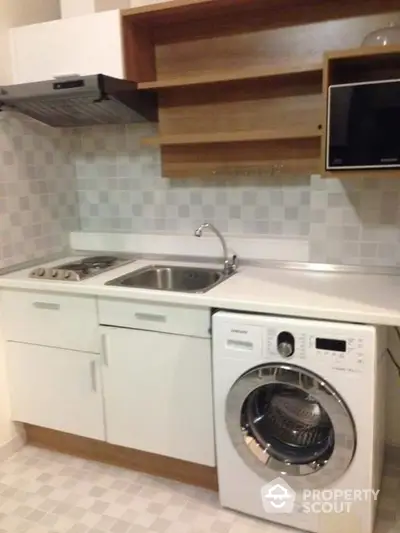 Modern compact kitchen with washing machine and sleek cabinetry